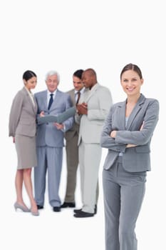 Smiling tradeswoman with folded arms and team behind her against a white background