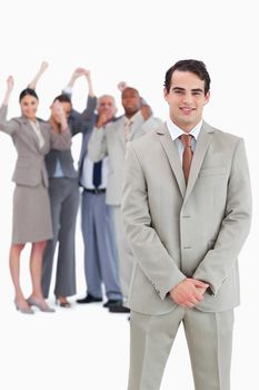 Businessman with cheering team behind him against a white background