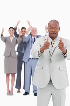 Tradesman with cheering team behind him giving thumbs up against a white background