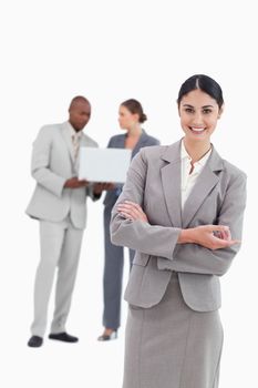 Saleswoman with talking colleagues behind her against a white background
