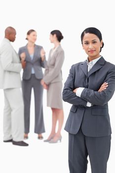 Saleswoman with negotiating trading partners behind her against a white background