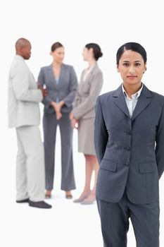 Businesswoman with negotiating trading partners behind her against a white background