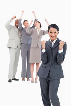 Successful saleswoman with cheerful team behind her against a white background