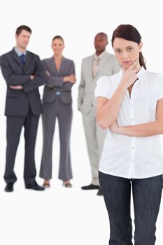 Thinking businesswoman with three colleagues behind her against a white background