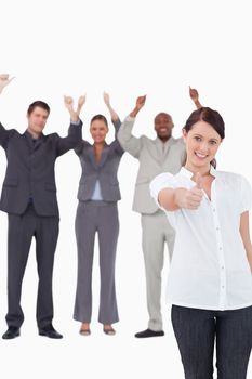 Businesswoman with cheering colleagues behind her giving approval against a white background