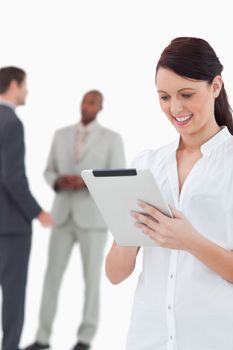 Saleswoman with tablet and associates behind her against a white background