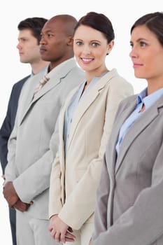 Smiling businesswoman standing between her associates against a white background