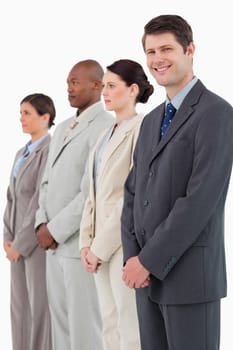 Smiling salesman standing next to his colleagues against a white background