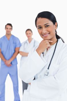 Smiling doctor with staff behind her against a white background