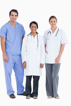 Smiling young medical staff standing together against a white background