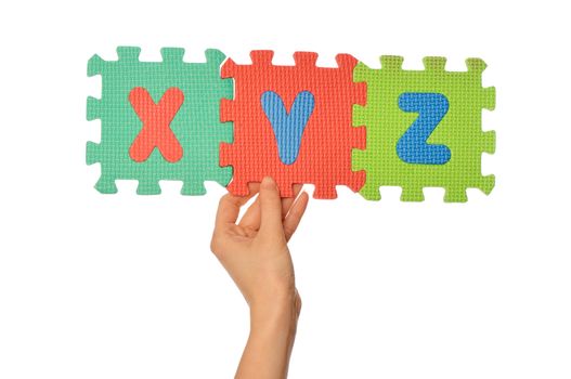 teacher holding in the hand the amusing colored educational puzzles with alphabet