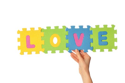 Teacher holding in the hand the amusing colored educational puzzles with the word love