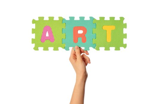 teacher holding in the hand the amusing colored educational puzzles with the word art