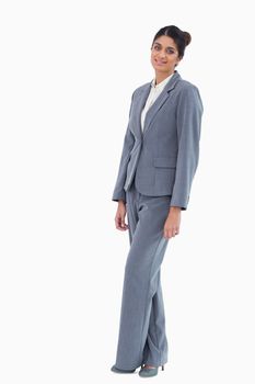 Smiling saleswoman standing against a white background