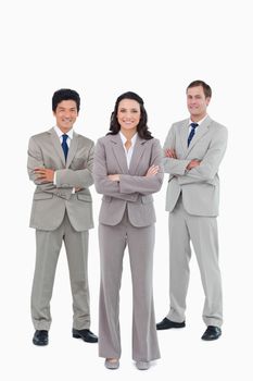 Smiling young tradesteam with arms folded against a white background