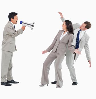 Businessman with megaphone shouting at colleagues against a white background
