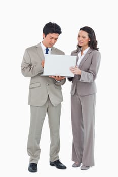 Young salesteam using laptop together against a white background