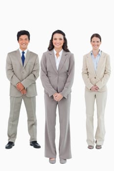 Smiling businesswoman with her team behind her against a white background