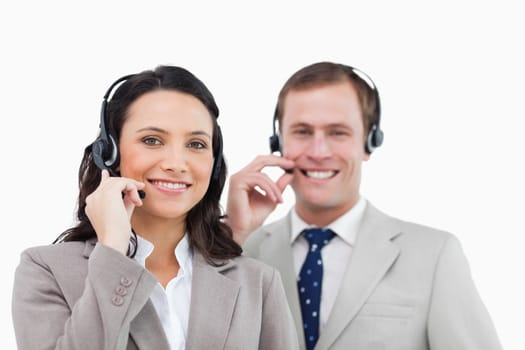 Smiling call center team with their headsets against a white background
