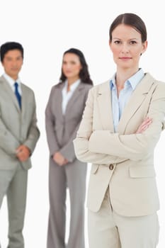 Confident tradeswoman with arms folded and team behind her against a white background