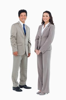 Smiling trading partners standing against a white background