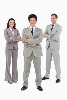 Smiling salesteam with folded arms against a white background