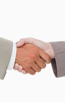 Side view of shaking hands closing a deal against a white background