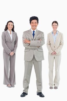 Smiling businessman with his staff behind him against a white background