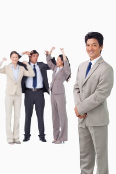 Businessman standing with cheering team behind him against a white background
