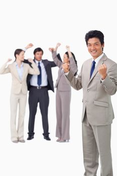 Successful businessman with cheering team against a white background