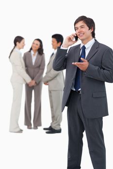 Tradesman talking on the phone with team behind him against a white background