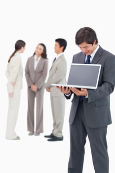 Salesman showing notebook screen with team behind him against a white background