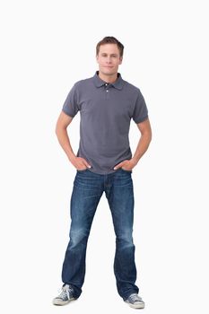 Young man with hands in his pockets against a white background