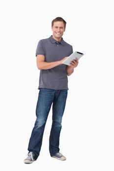 Smiling young man with his tablet computer against a white background