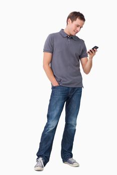 Young man typing text message on his cellphone against a white background