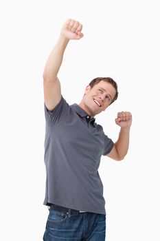 Successful young man celebrating against a white background