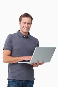 Smiling young man with his laptop against a white background