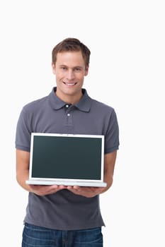 Smiling young man showing screen of his notebook against a white background