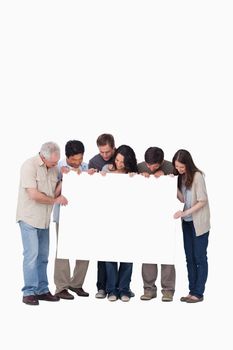 Group of friends holding blank sign together against a white background