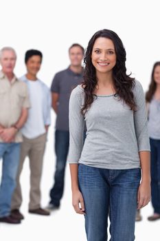 Smiling young woman with friends standing behind her against a white background