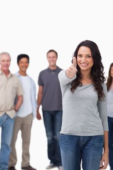 Smiling woman giving thumb up with friends behind her against a white background
