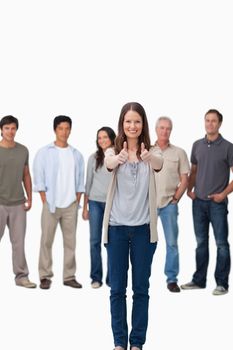 Approval given by smiling woman with friends behind her against a white background