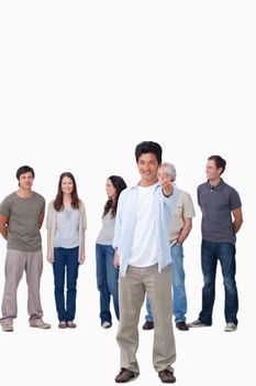 Smiling male giving thumb up with friends behind him against a white background