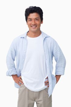 Smiling male with hands on his hip against a white background