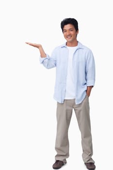 Smiling male holding his palm up against a white background
