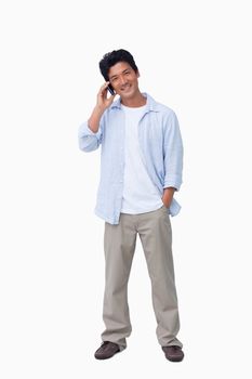 Smiling male on cellphone against a white background