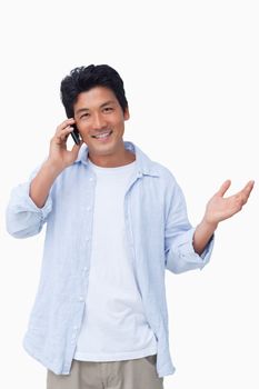 Smiling male talking on the cellphone against a white background