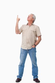 Mature male looking and pointing up against a white background