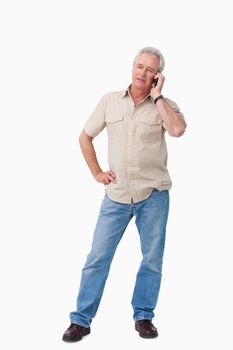 Mature man talking on his cellphone against a white background