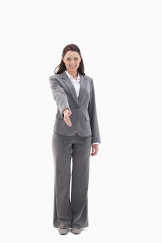 Businesswoman smiling and holding out her hand against white background